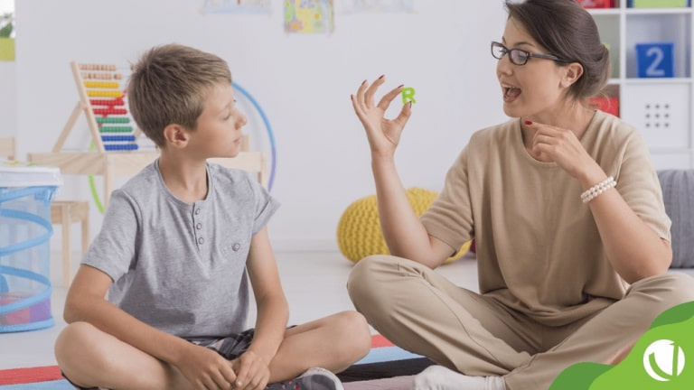 Pai e filho autista estudando juntos com materiais educativos inclusivos e mapa do Brasil